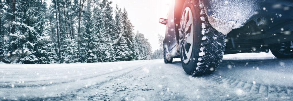 Nahaufnahme von Autoreifen im Winter auf einer schneebedeckten Straße