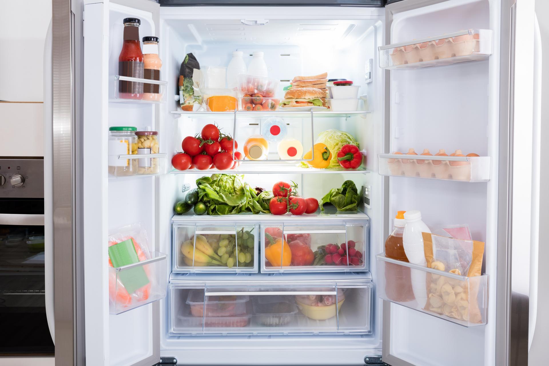 Offener Kühlschrank, gefüllt mit frischem Obst und Gemüse